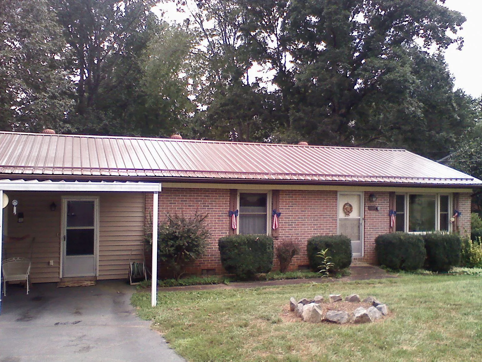 Bronze metal roof and carport on a brick ranch home in Cameron